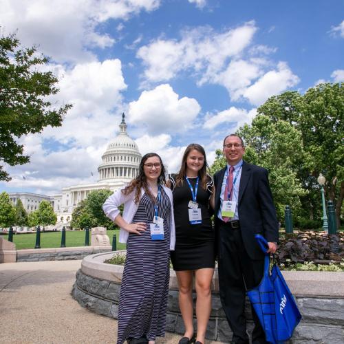 Advocacy Day participants pose in with the Capitol in the background.